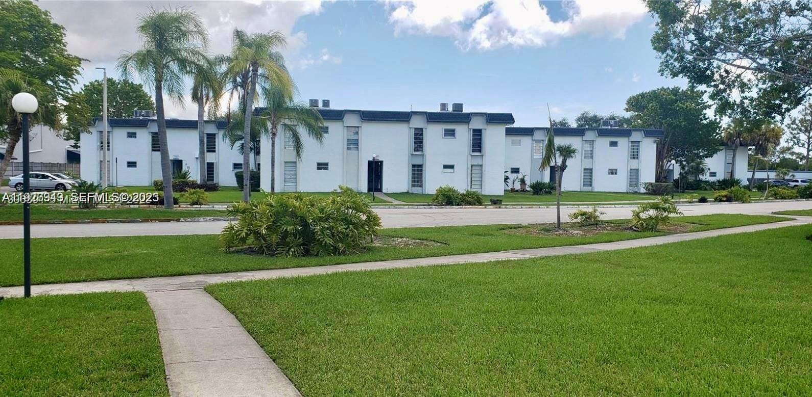a view of a big building with a big yard and plants