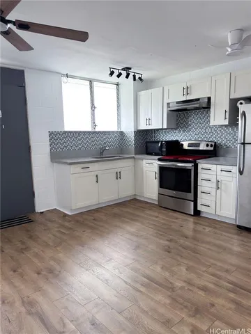 a kitchen with granite countertop a stove a sink and a refrigerator