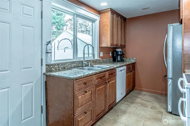 a view of a granite countertop sink and a window