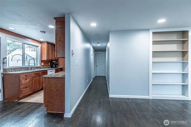 a view of kitchen with stainless steel appliances granite countertop cabinets and wooden floor