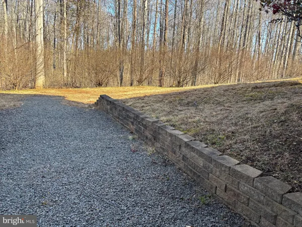 a view of dirt field with trees in the background
