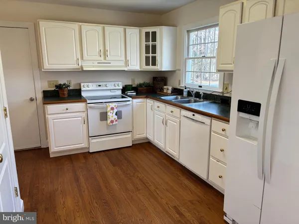 a kitchen with stainless steel appliances white cabinets and a window