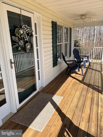 a view of a balcony with chairs and wooden floor