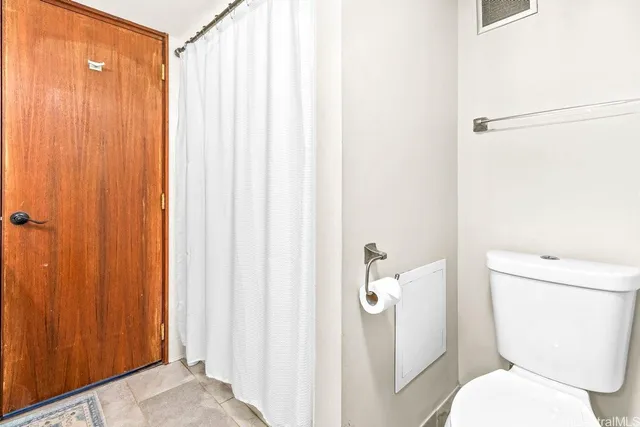 a white toilet sitting next to a shower curtain