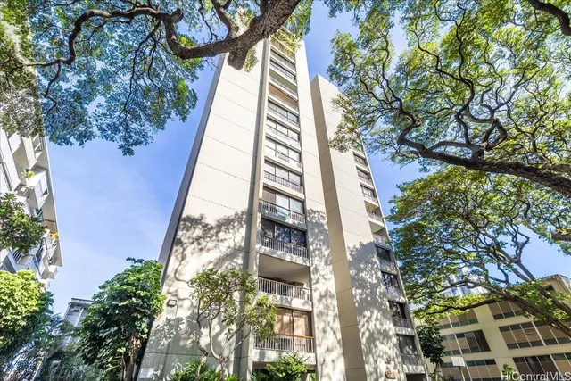 a front view of a multi story building with a yard