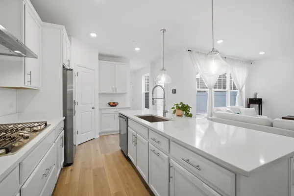 a large kitchen with stainless steel appliances lots of counter space and a sink