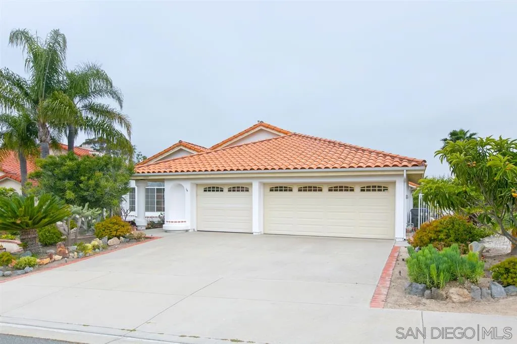 5064 Frazee Road Oceanside, CA 92057 - Photo 1 of 25 a front view of a house with a yard and garage