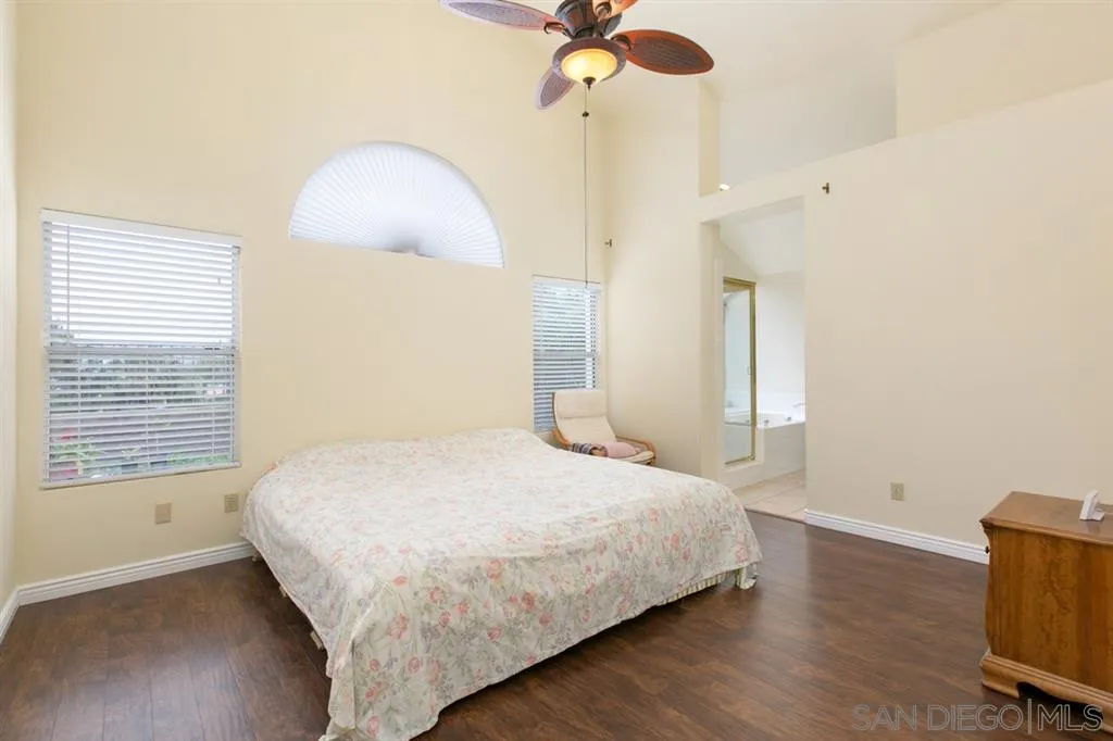 5064 Frazee Road Oceanside, CA 92057 - Photo 17 of 25 a bedroom with a bed and a chandelier