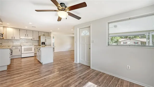 a view of kitchen with granite countertop cabinets and refrigerator