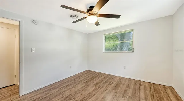 a view of empty room with wooden floor