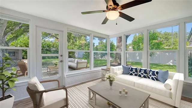 a living room with furniture and a large window with garden view