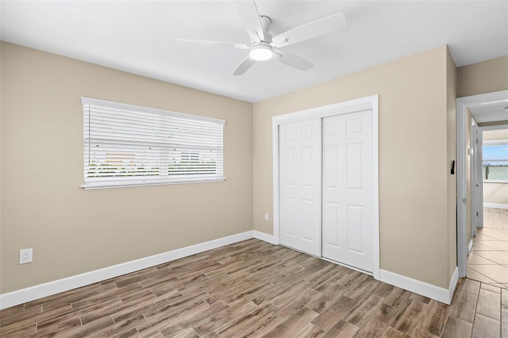 708 Sunset Cove Madeira Beach, FL 33708 - Photo 32 of 61 a view of an empty room with wooden floor and a ceiling fan