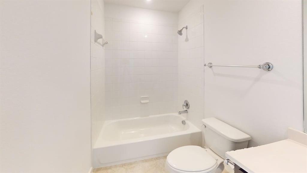 9628 Boulder Pt Road Oak Point, TX 75068 - Photo 22 of 35 Bathroom featuring a white subway tile shower surround, a built-in tub with chrome fixtures, a white toilet, and a light-toned vanity with an integrated sink