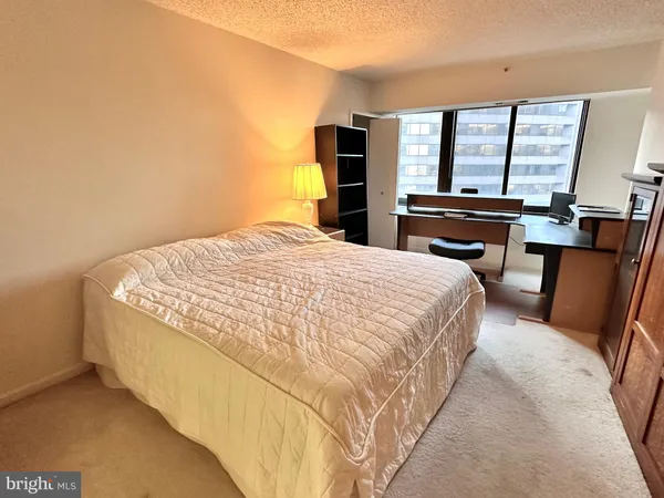a spacious bedroom with a bed and wooden floor