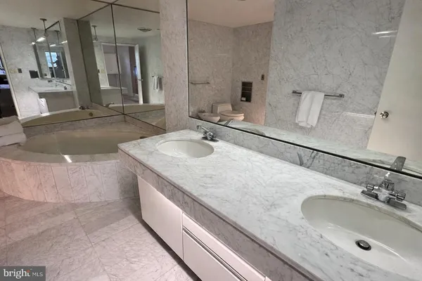 a bathroom with a granite countertop sink a mirror and vanity