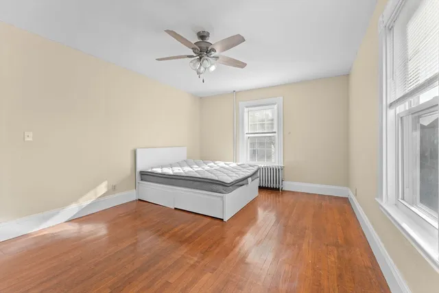 a living room with a bed and a ceiling fan