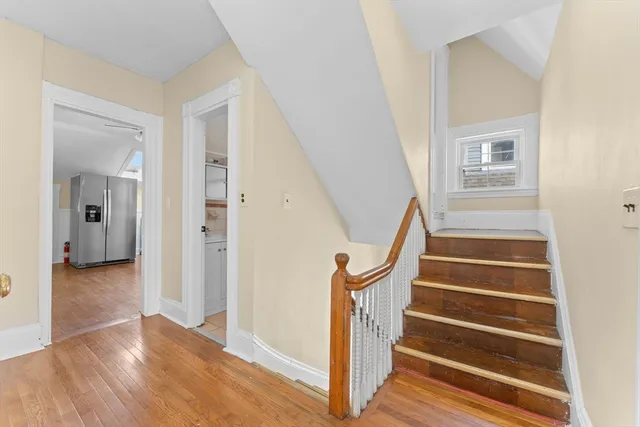 a view of entryway with wooden floor and a front door