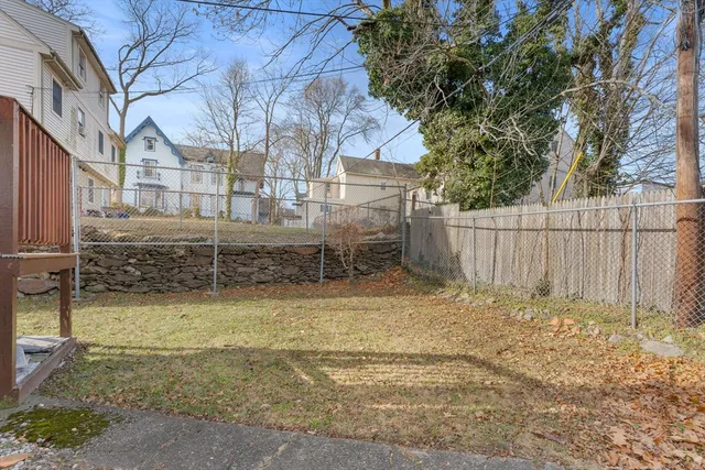 a view of a yard with wooden fence