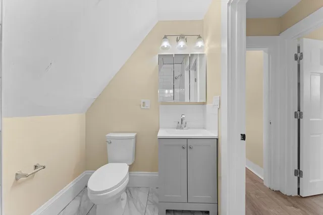 a bathroom with a toilet a sink and mirror