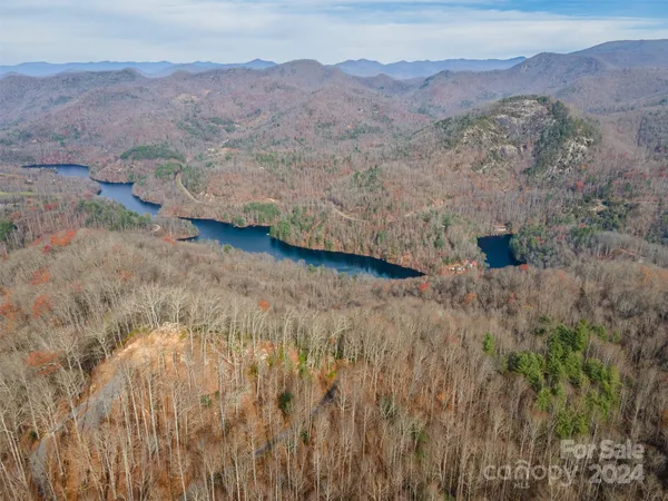 a view of a dry field with mountains in the background