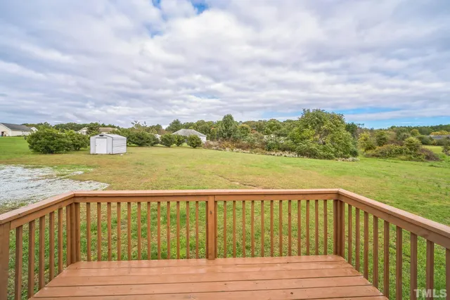a view of house with a backyard and balcony