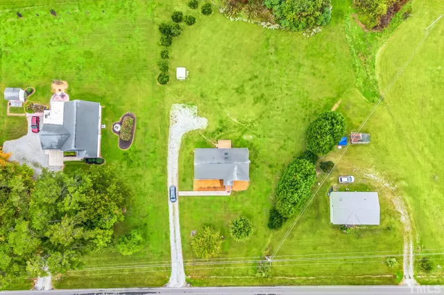 a front view of a house with a yard and trees