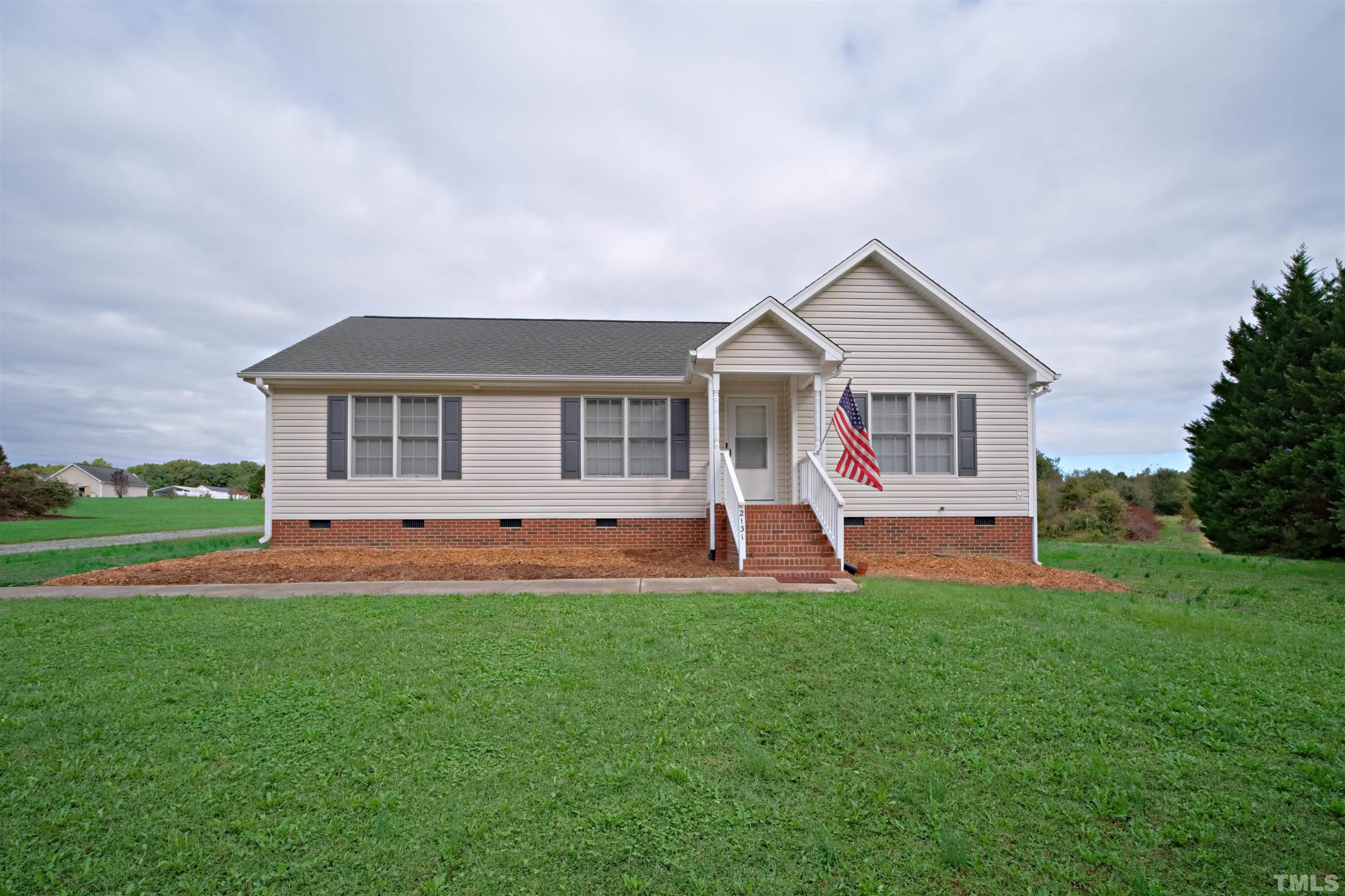 2131 Antioch Church Road Roxboro, NC 27574 - Photo 4 of 26 a front view of a house with a yard and trees