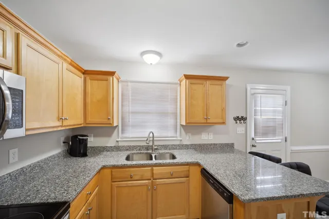 a kitchen with a stove a refrigerator and wooden cabinets