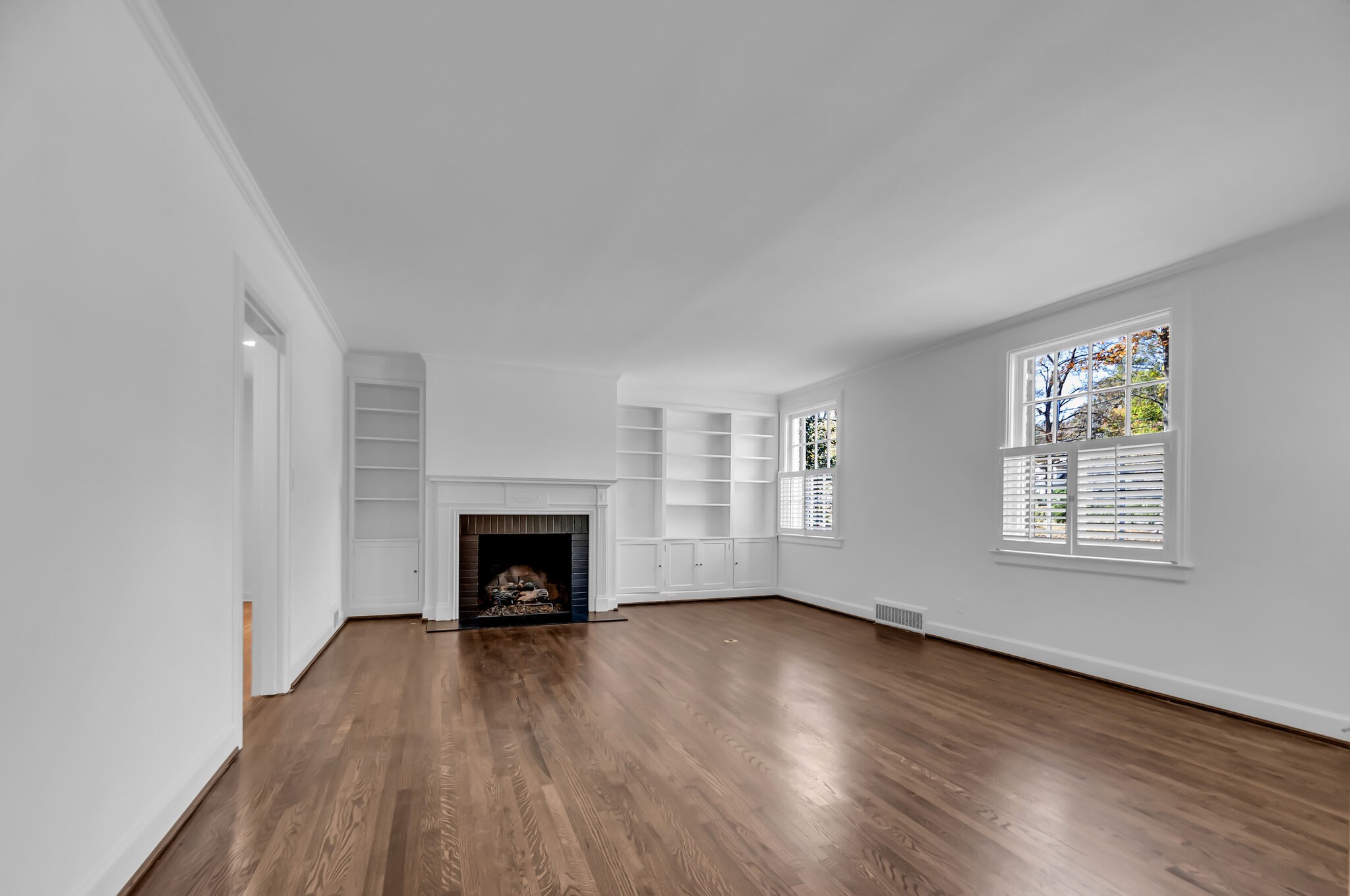 4206 Sneed Road Nashville, TN 37215 - Photo 6 of 56 an empty room with wooden floor fireplace and windows