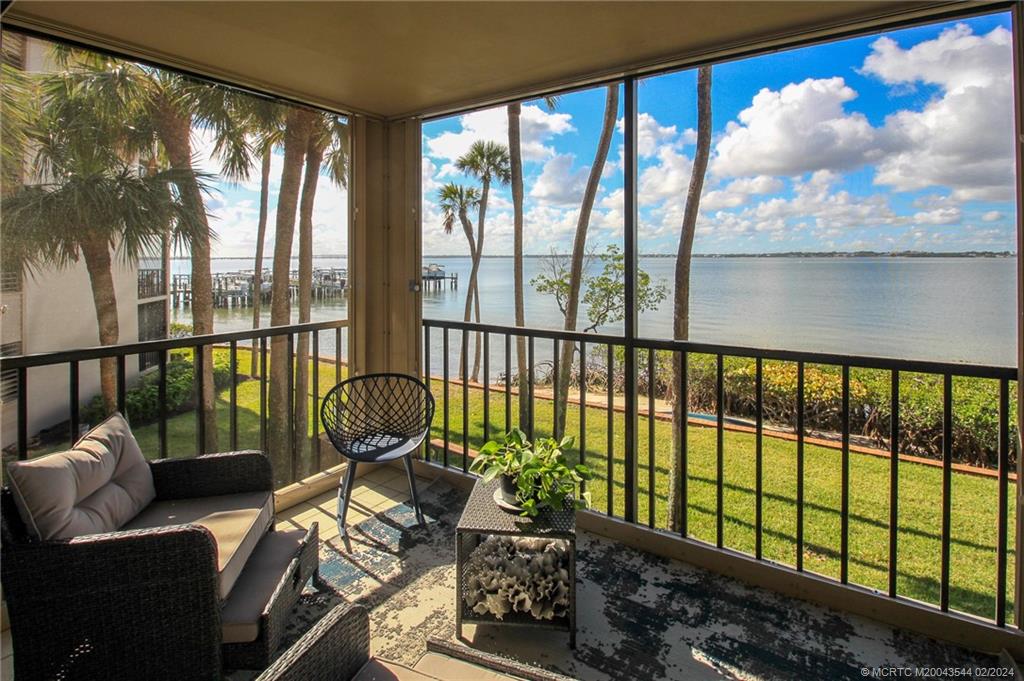 4440 Northeast Sandpebble Trace, Unit 201 Stuart, FL 34996 - Photo 1 of 23 a view of a living room and floor to ceiling window and wooden floor