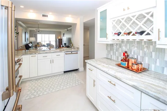 a kitchen with white cabinets and sink