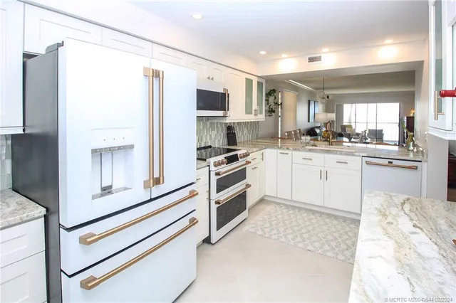 a kitchen with stainless steel appliances granite countertop a refrigerator and a stove top oven