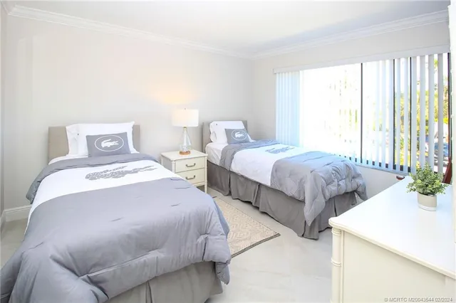 a bedroom with two beds and a large window