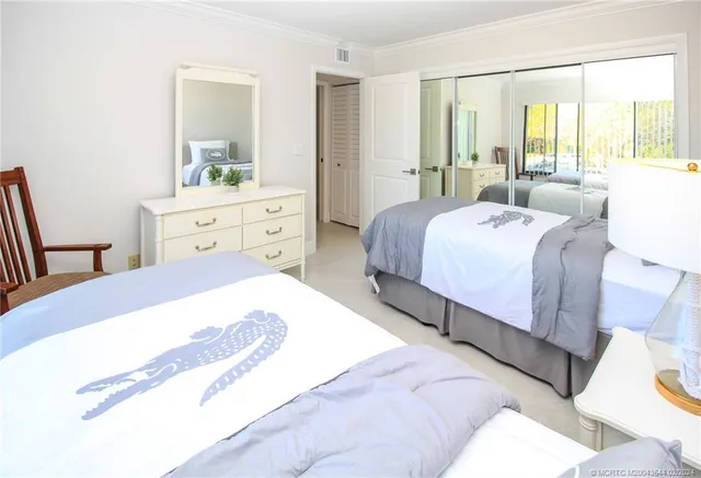 a bedroom with a bed and large windows