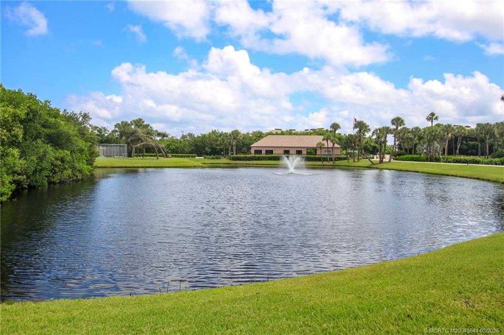 4440 Northeast Sandpebble Trace, Unit 201 Jensen Beach, FL 34957 - Photo 25 of 32 a view of a lake with houses in the back