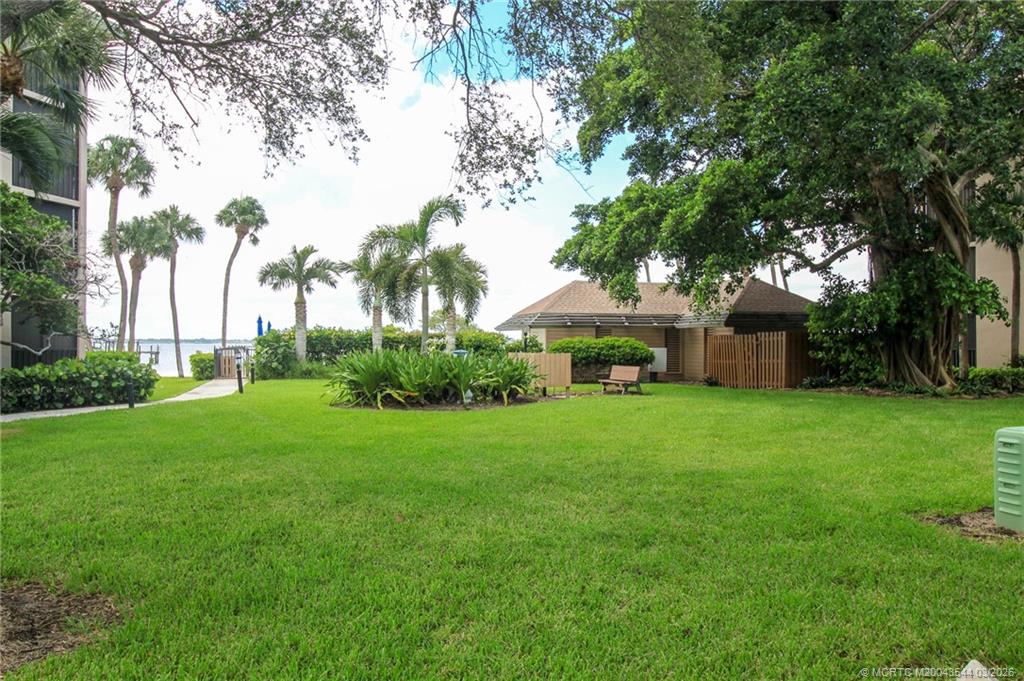 4440 Northeast Sandpebble Trace, Unit 201 Jensen Beach, FL 34957 - Photo 28 of 32 a view of a house with backyard and garden