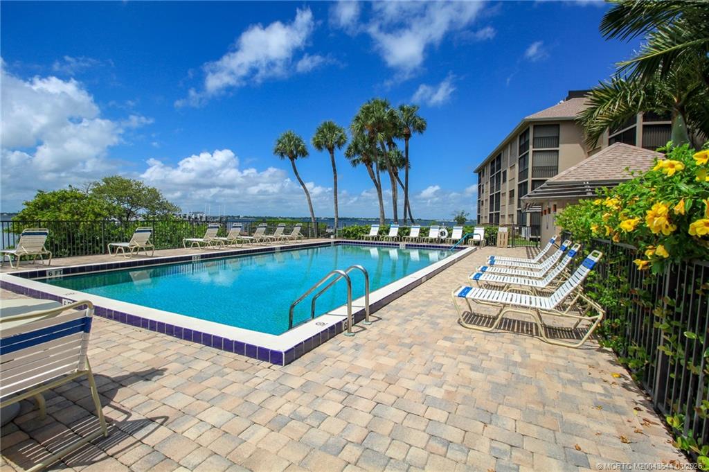 4440 Northeast Sandpebble Trace, Unit 201 Jensen Beach, FL 34957 - Photo 29 of 32 a view of swimming pool with a lounge chairs