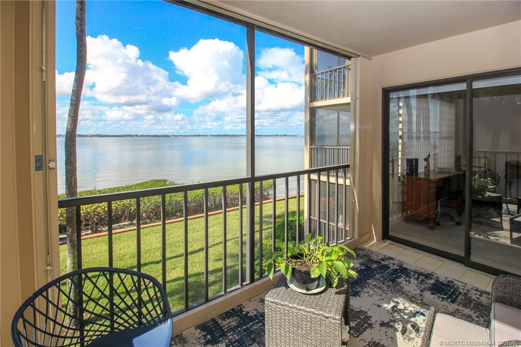4440 Northeast Sandpebble Trace, Unit 201 Jensen Beach, FL 34957 - Photo 3 of 32 a view of a porch with a chair