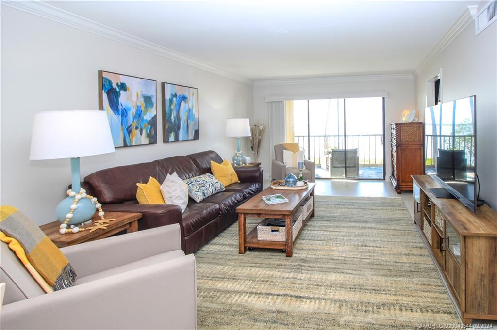 4440 Northeast Sandpebble Trace, Unit 201 Stuart, FL 34996 - Photo 5 of 23 a living room with furniture and a large window
