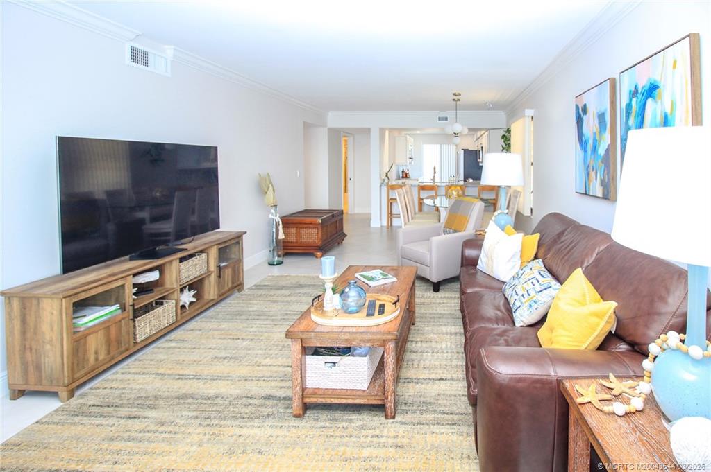 4440 Northeast Sandpebble Trace, Unit 201 Jensen Beach, FL 34957 - Photo 8 of 32 a living room with furniture and a flat screen tv