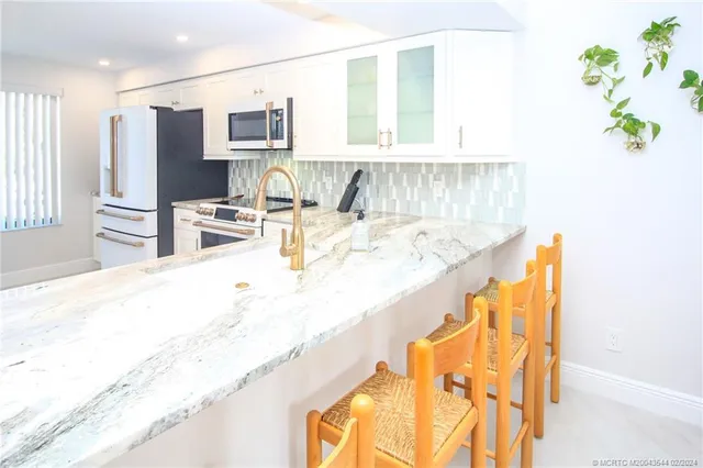 a living room with stainless steel appliances kitchen island granite countertop furniture and a kitchen view