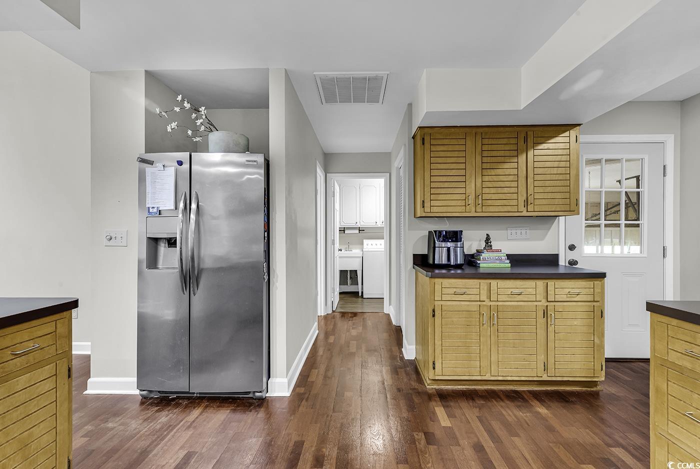 1305 Forest View Road Conway, SC 29526 - Photo 15 of 40 Kitchen featuring stainless steel fridge with ice dispenser, dark countertops, dark wood-type flooring, baseboards, and washer / clothes dryer