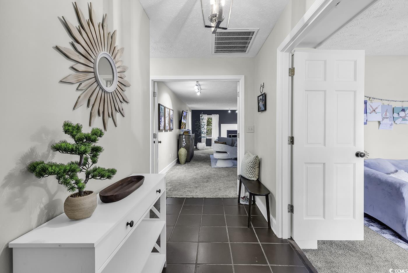 1305 Forest View Road Conway, SC 29526 - Photo 2 of 40 Hallway featuring dark carpet, a textured ceiling, dark tile patterned flooring, and baseboards