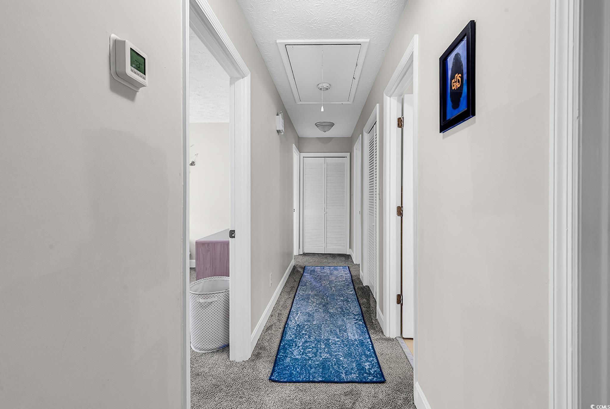 1305 Forest View Road Conway, SC 29526 - Photo 25 of 40 Hallway featuring attic access, baseboards, a textured ceiling, and carpet