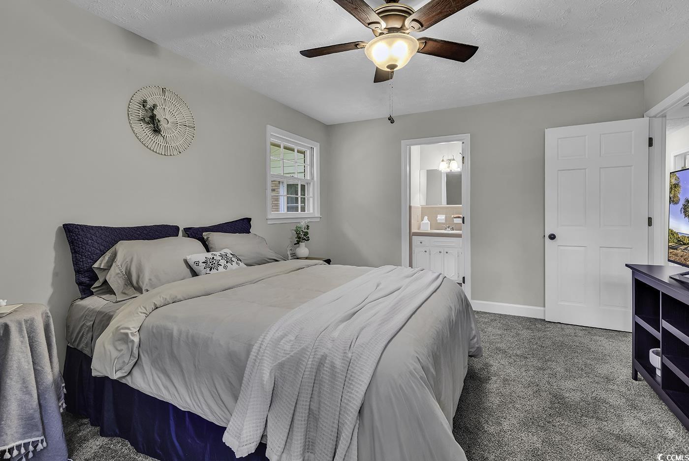 1305 Forest View Road Conway, SC 29526 - Photo 29 of 40 Bedroom featuring carpet floors, a textured ceiling, ceiling fan, connected bathroom, and baseboards