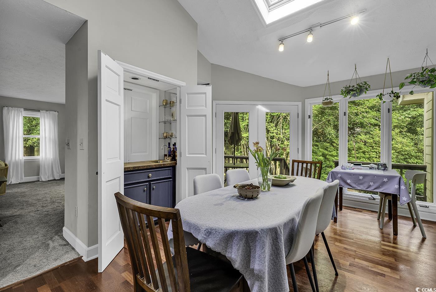 1305 Forest View Road Conway, SC 29526 - Photo 9 of 40 Dining room featuring lofted ceiling, a dry bar, track lighting, baseboards, and dark wood-type flooring
