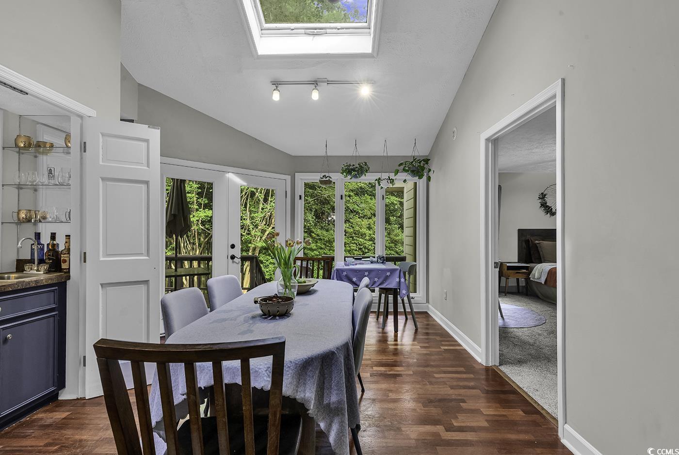 1305 Forest View Road Conway, SC 29526 - Photo 10 of 40 Dining space featuring dark wood-type flooring, a skylight, lofted ceiling, french doors, and baseboards
