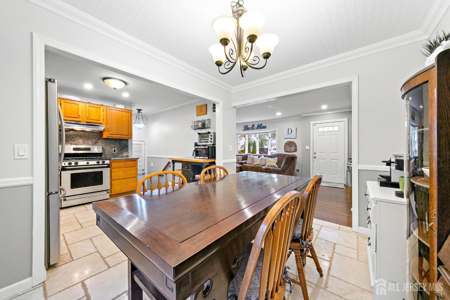 8 Beverly Drive Old Bridge, NJ 08857 - Photo 7 of 34 a dining room with wooden floor a chandelier a wooden table and chairs