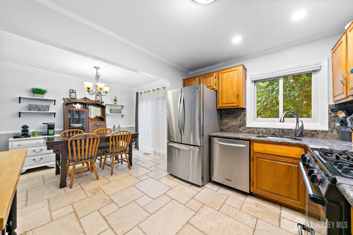 8 Beverly Drive Old Bridge, NJ 08857 - Photo 9 of 34 a kitchen with stainless steel appliances granite countertop a refrigerator a sink dishwasher a dining table and chairs with wooden floor