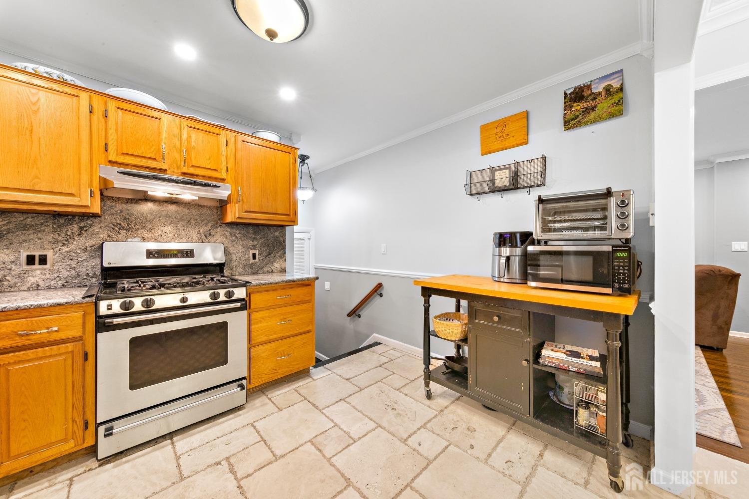 8 Beverly Drive Old Bridge, NJ 08857 - Photo 10 of 34 a kitchen with stainless steel appliances granite countertop a stove a sink and a microwave